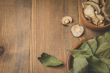 Bay leaf on wooden ware with dried mushrooms. Top view/In rural style. Bay leaf on wooden ware with dried mushrooms.