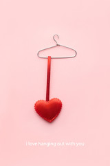 Hanging out with you / Creative valentines concept photo of a heart on a hanger on pink background.