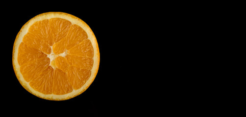 sliced orange closeup isolated on black background
