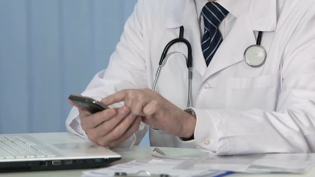 Health professional viewing test results on smartphone, sliding e-documents