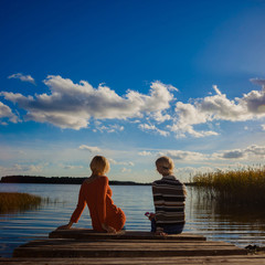 Two middle-aged women friends on the shore. Portrait of beautiful young women standing together on the beach during sunset. Female best friends enjoying a day on the sea shore.