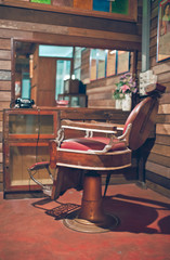 Antique red leather chair at a barbershop in vertical picture vintage style.