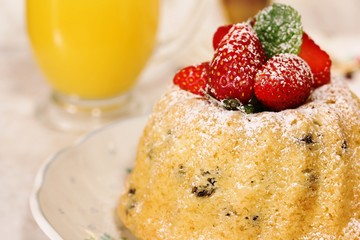 Homemade Mini Bundt Cake topped with fresh strawberries and dusted in powdered sugar, selective focus