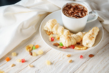 Cup of hot cocoa and cream cakes