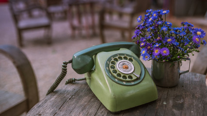Retro green rotary dial buttons telephone and flowers in a basket vintage style.