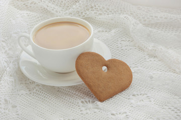 Cup of coffee with cookies as heart on lace. Windowsill.