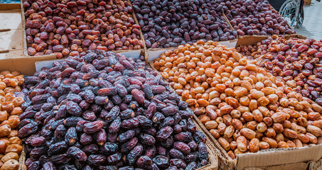 A fresh date-palm and dry date-palm on a wooden trays in the market vintage style.