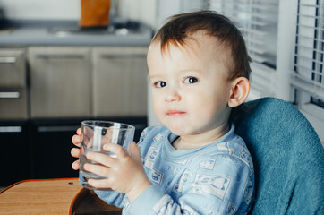 child drinks water from a glass