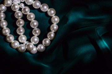 White pearl bracelet on dark green velvet.