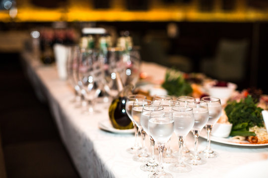 Wineglasses with water stand on rich served dinner table