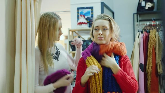 Two friends try on things in a clothing store. Look in the mirror
