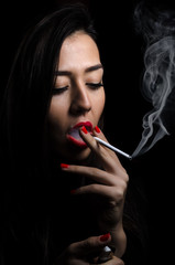 Portrait of the beautiful elegant girl smoking cigarette on black background.