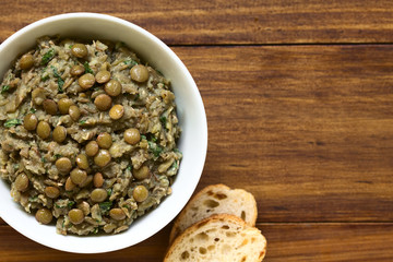 Lentil and parsley spread in bowl with slices of bread on the side, photographed overhead with natural light (Selective Focus, Focus on the top of the spread)
