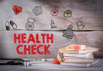 Health Check. Stack of books and a stethoscope on a wooden background.
