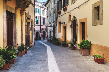 Fototapeta na wymiar Spring streets of the old Tuscan town. Colorful flowers bloom an