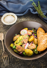 Meat,potato,garden radish salad in brown bowl.