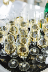 A lot of wine glasses with a cool delicious champagne or white wine at the bar. Alcohol background.