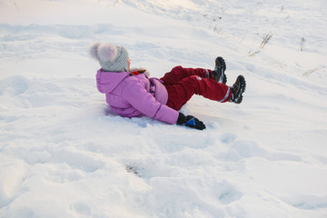 Fototapeta na wymiar girl climb down on a snow hill