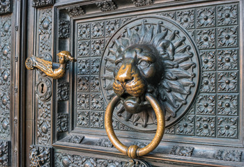 Bronze knocker in the shape of a lion's head at the gate of the Cologne Cathedral, the most famous church in Germany.