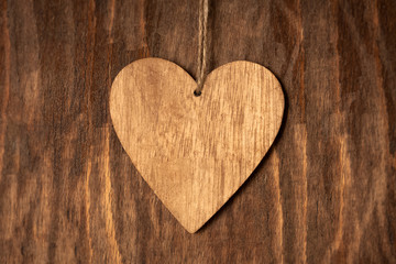 One Wooden Brown Heart With Rope On Wooden Background Close Up.
