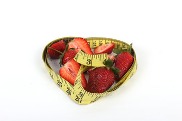 big juicy red ripe strawberries and measure tape isolated on white