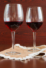 Two glasses of wine on a wooden table.