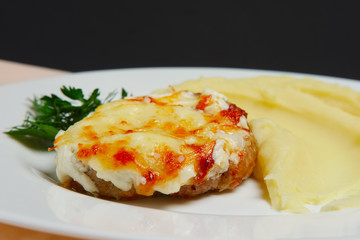 Meat cutlet with cheese and mashed potato. Closeup photo with se