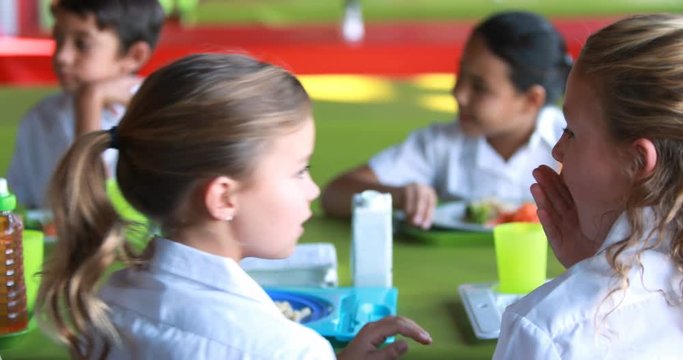Schoolgirls whispering while having meal in school cafeteria 4k