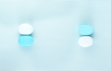 Pair of white and light blue eggs on a colorful striped backdrop. Creative design, minimal concept. Negative space
