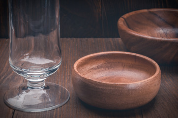 empty beer glass and empty, wooden plates/empty beer glass and empty, wooden plates on a wooden background
