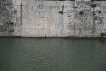 Castle wall next to the river in the royal gardens of the palace