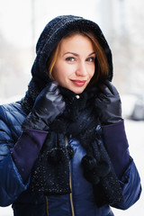 Closeup portrait of young woman standing outdoors in winter