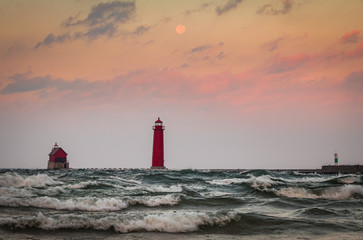 full moon over lighthouse at sunrise