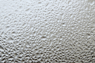 Abstract shapes on a window created by frozen water drops