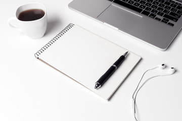 Cup With Coffe, Notebook With Pen And Headphones Near Laptop  