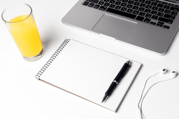 Glass With Juice, Notebook With Pen And Headphones Near Laptop 