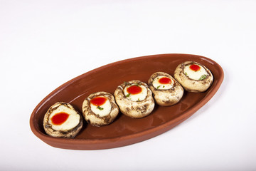 Mushroom with melted cheese filling in a casserole isolated on white background