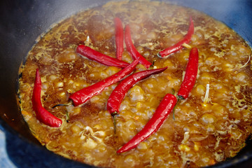 National Uzbek dish pilaf, pilaw, plov, rice with meat in big pan. Cooking process in a cauldron on...