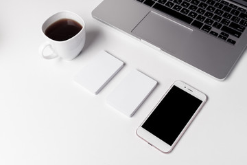 Cup With Coffee, Business Cards And Smartphone Near Laptop