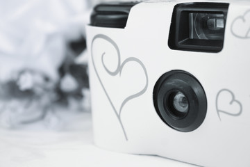 Disposable white wedding camera with silver hearts on the front.