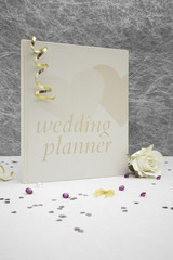 Wedding planner book on a White tablecloth with gold ribbons,bow