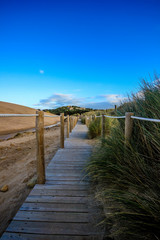 Fototapeta na wymiar Wooden path to the beach on the dunes. Guincho beach in Cascais, Portugal