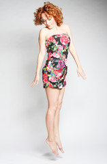 Young charming female in dress jumping