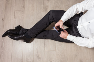 Mężczyzna korzysta z telefonu komórkowego w czasie przerwy w pracy biurowej