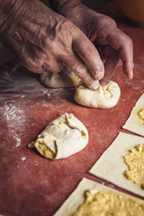 Old senior man hands rolling and wrapping pastry dough
