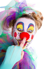 Clown fasst sich an die Nase