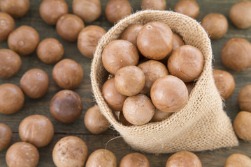 Organic Macadamia nut on wooden table (Macadamia integrifolia)