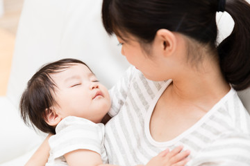 asian mother and baby relaxing on the sofa