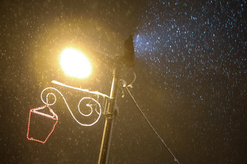 Illuminating street lamp in snowfall