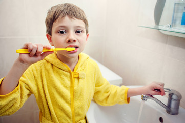 Personal hygiene. Care of an oral cavity. The boy brushes teeth.